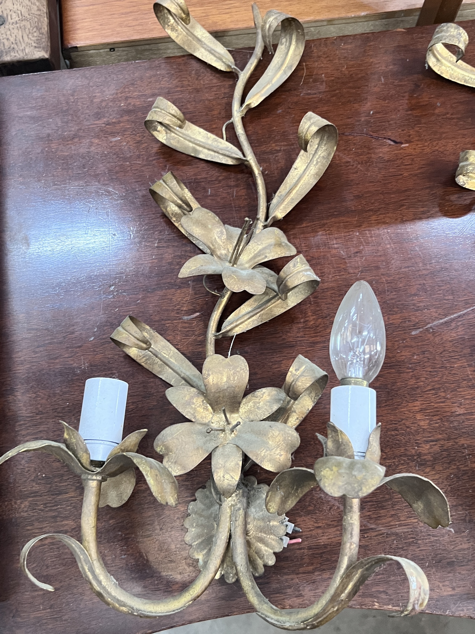 A set of three gilt metal floral two branch wall lights